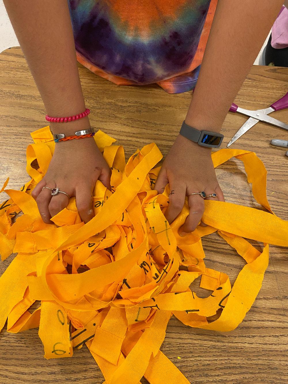 Thesis 2 / A close view of yellow paper scraps and small cut pieces arranged in a scattered pattern.