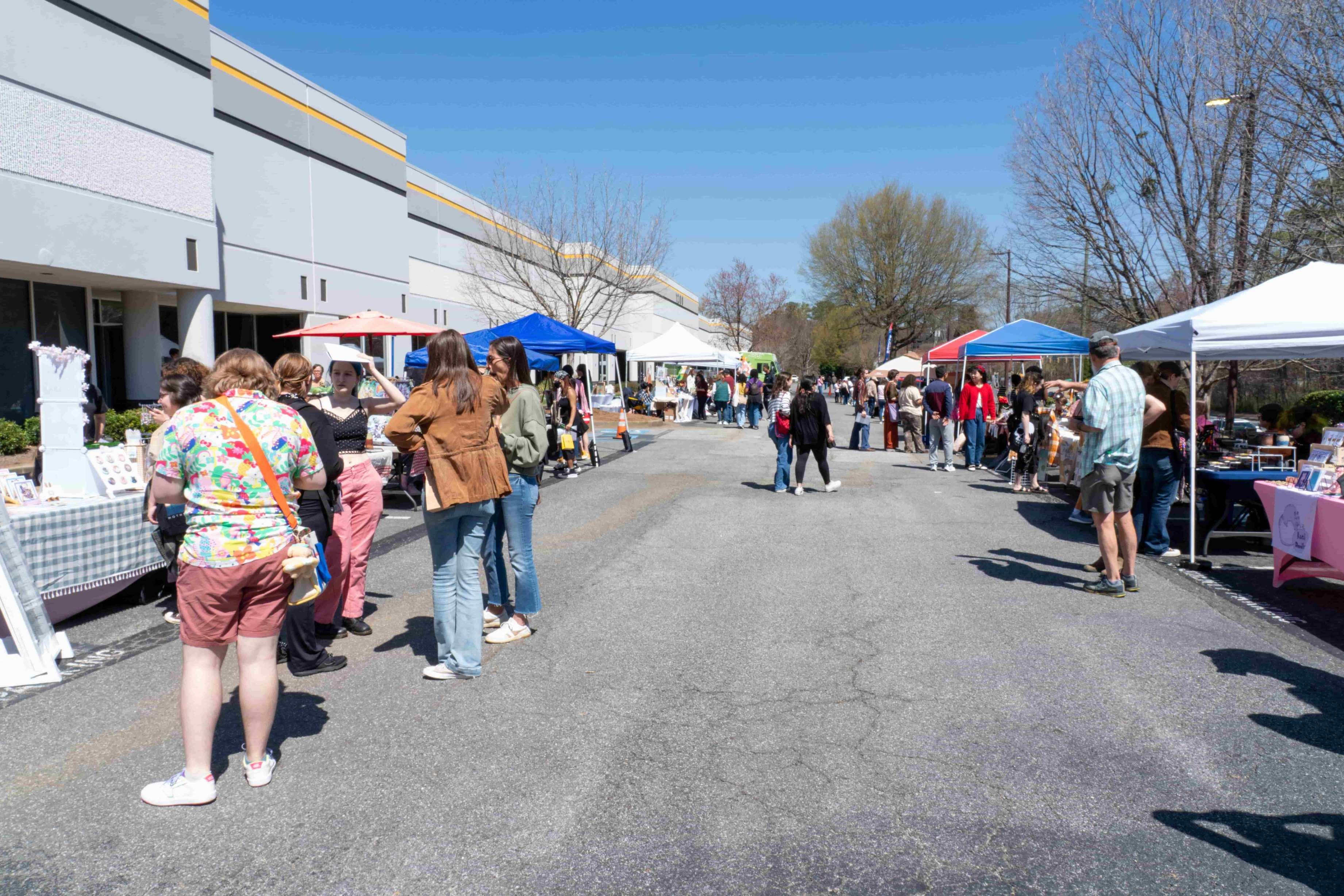 Sunny spring day with student vendor tents in parking lot for the Artist Market.   / 