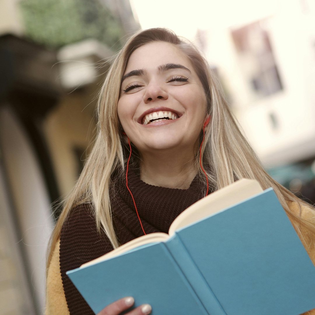 close up on female student smiling and holding book