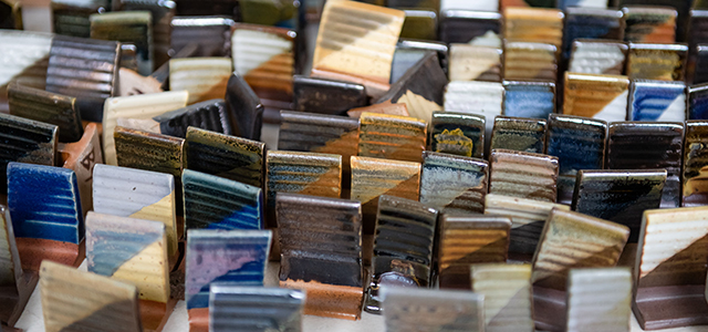 many colorful ceramic glazing tests on a table