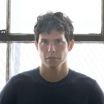 Headshot of male artist in front of a window