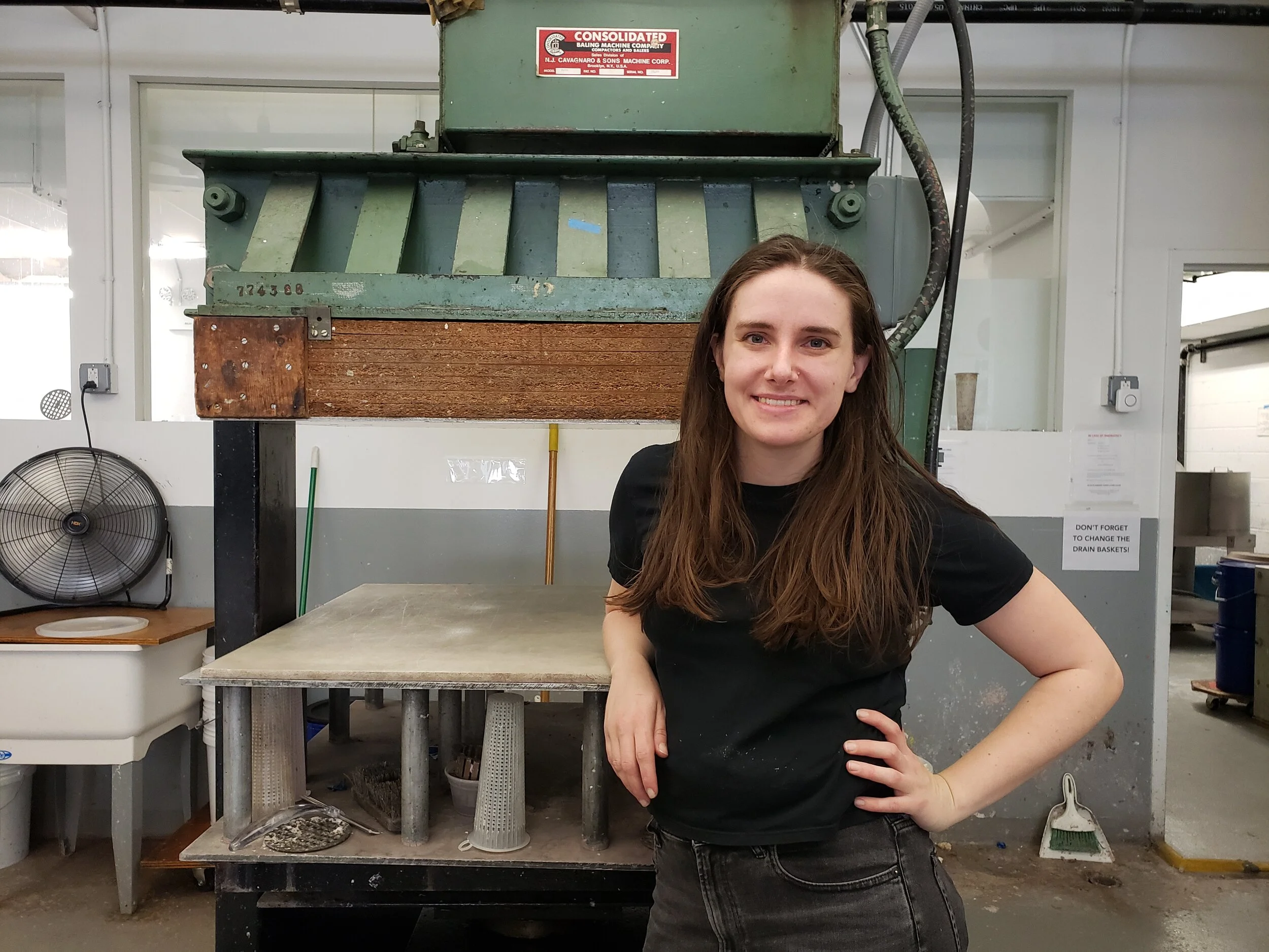 woman smiling and standing in front of large machine
