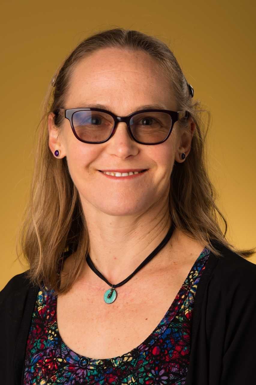 headshot of a woman in front of a yellow background