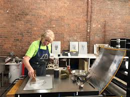 woman making paper on large press