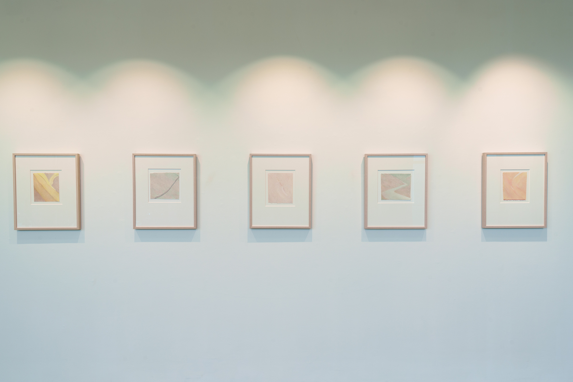images of small colored pencil works of landscapes on a gallery wall