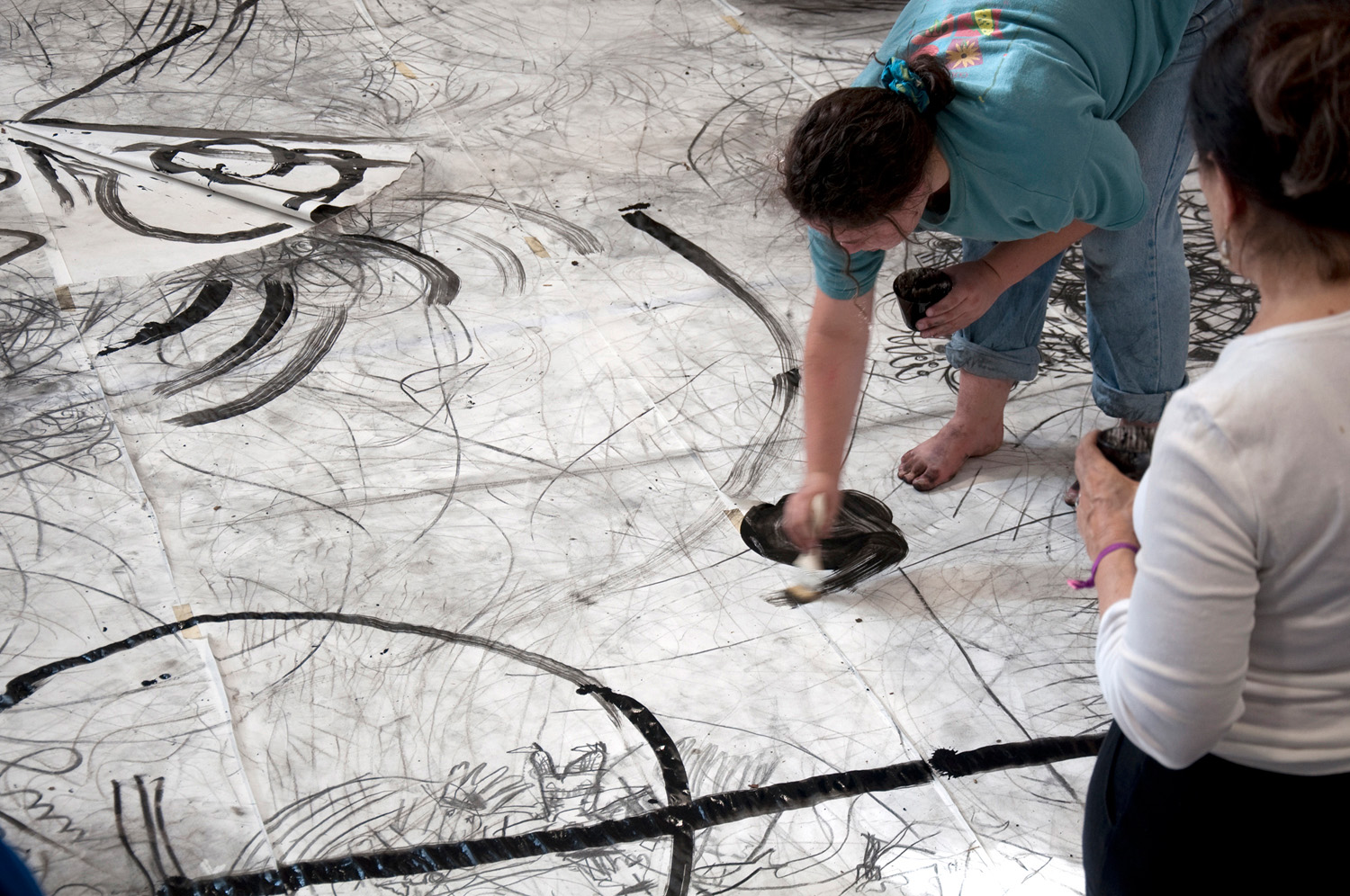 image of woman drawing on large sheet on the floor