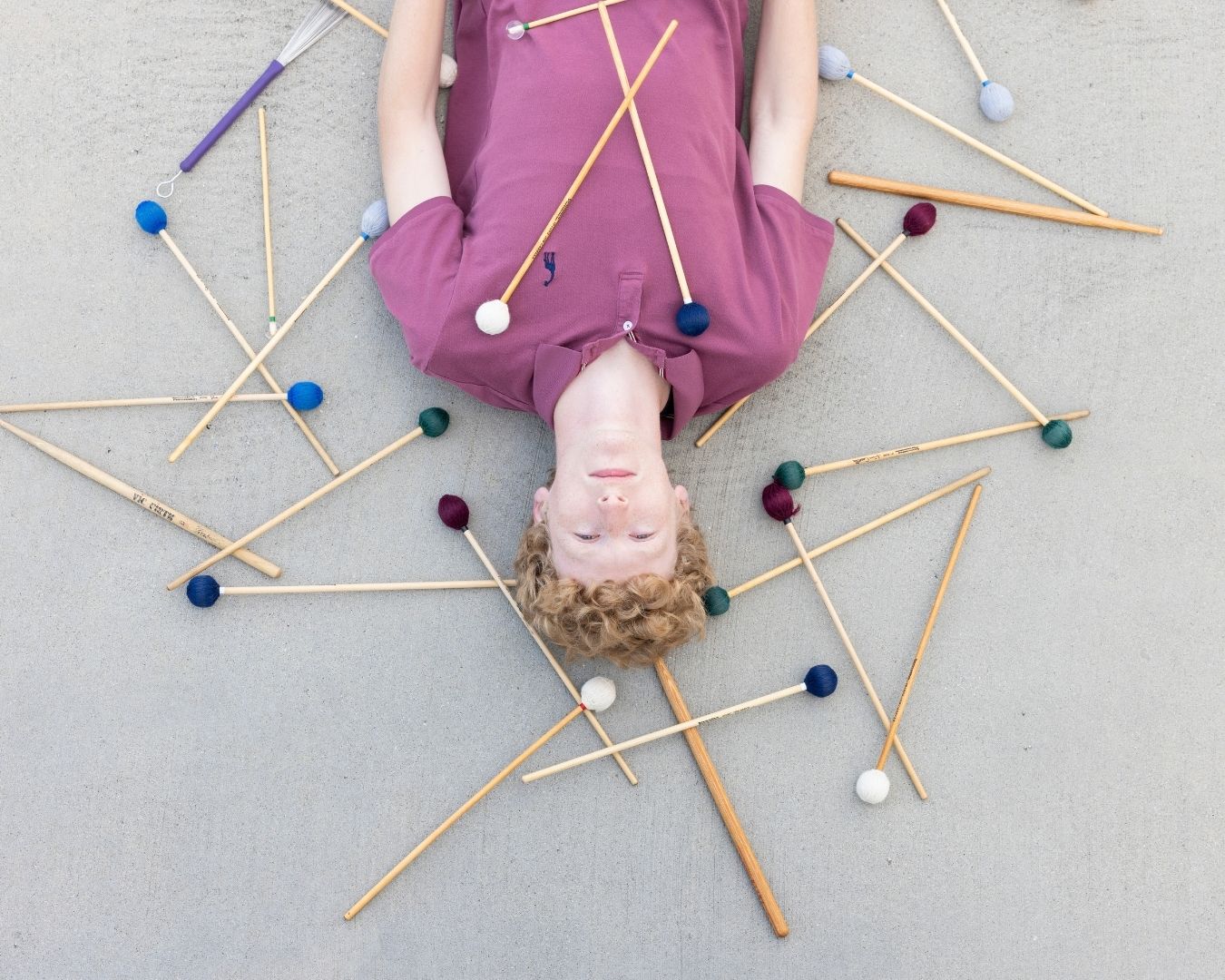 percussionist_laying_on_ground_with_drumsticks