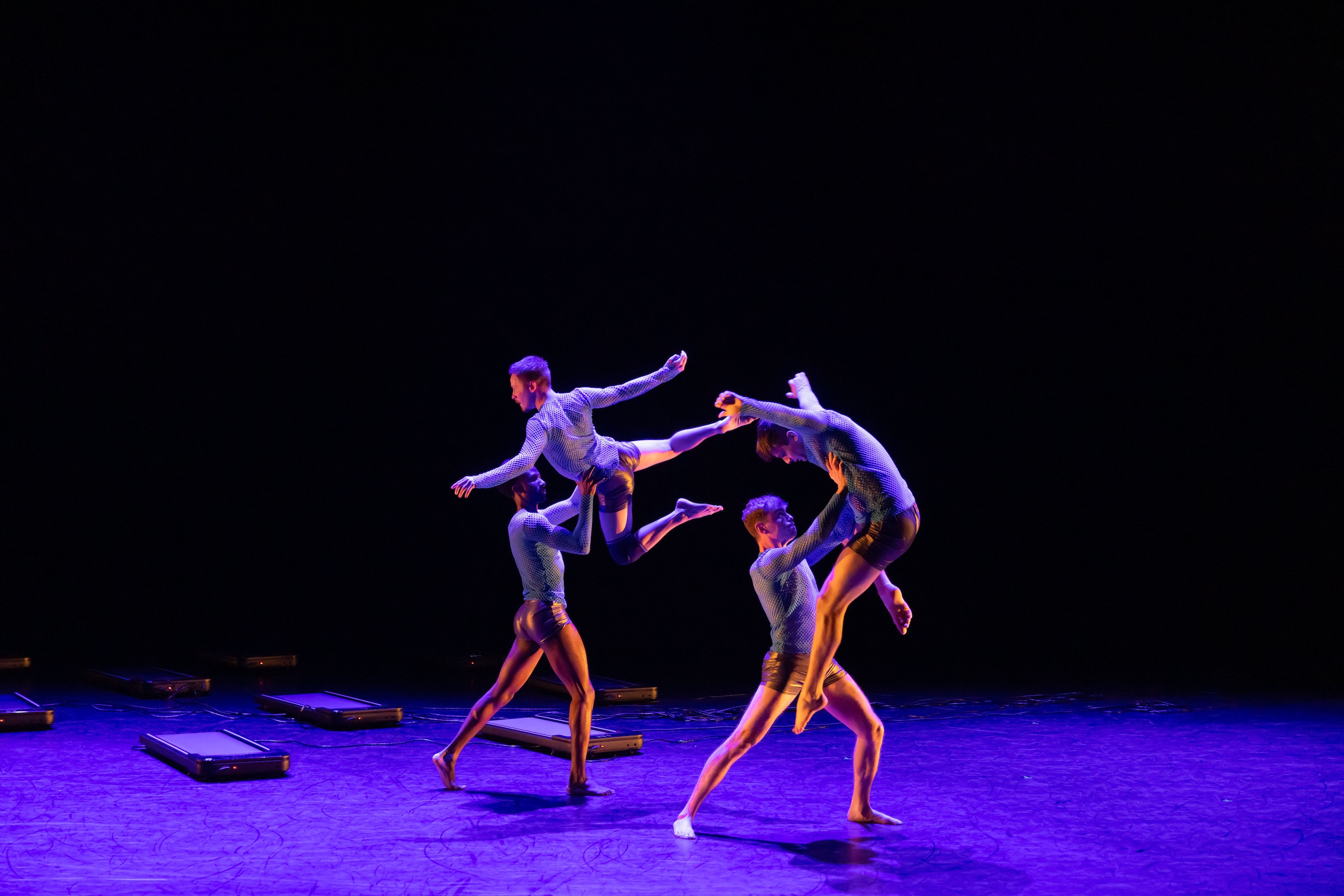 male dancers lift one another in an elegant sequence as a part of labyrinth