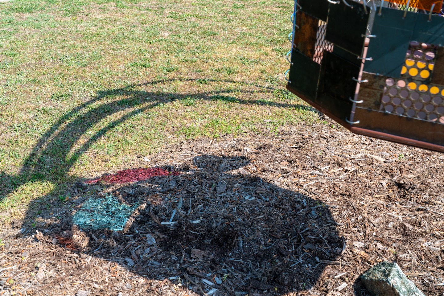 a sculpture reflects light onto the grass beneath