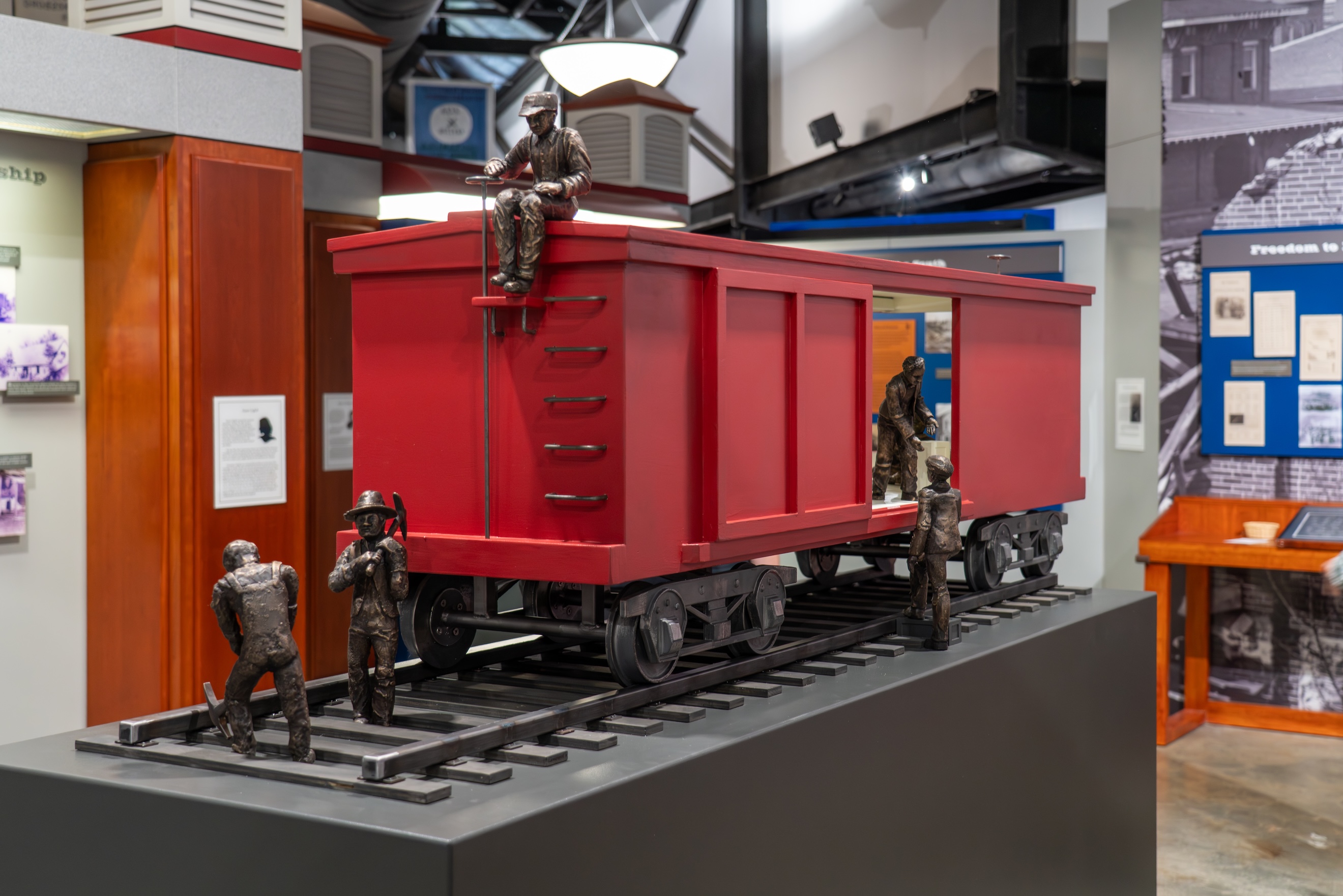 model railroad car with bronze cast statues of people working