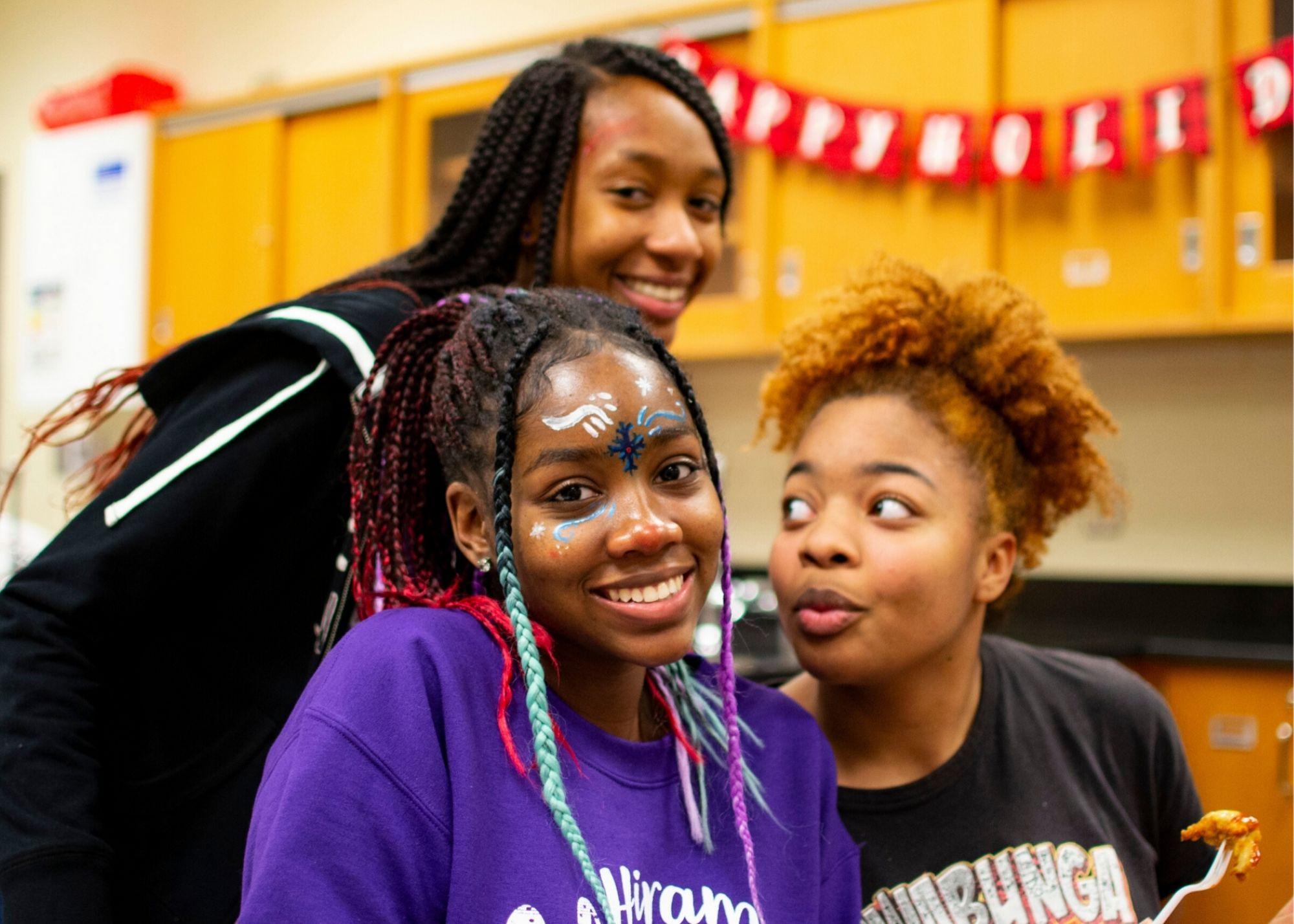  Students smiling with a holiday banner hanging in the background.  / Hiram High School Upward Bound celebrates the holidays and learns about college planning 