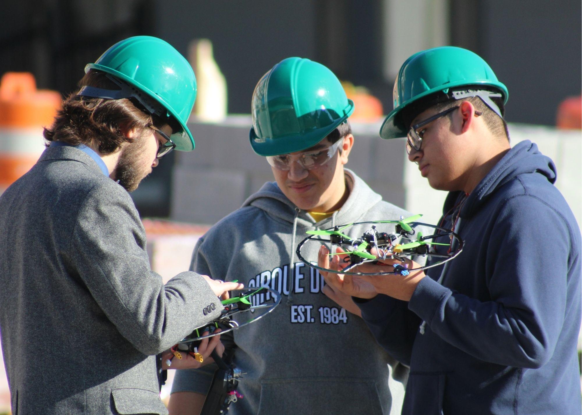 Three students wearing hardhats and holding drones  / KSU TRIO's groundbreaking Drone Program introduces students to the basics of drone flying, ethics, and mechanics, and the program gives students the opportunity to test for their FAA Pilot's License 