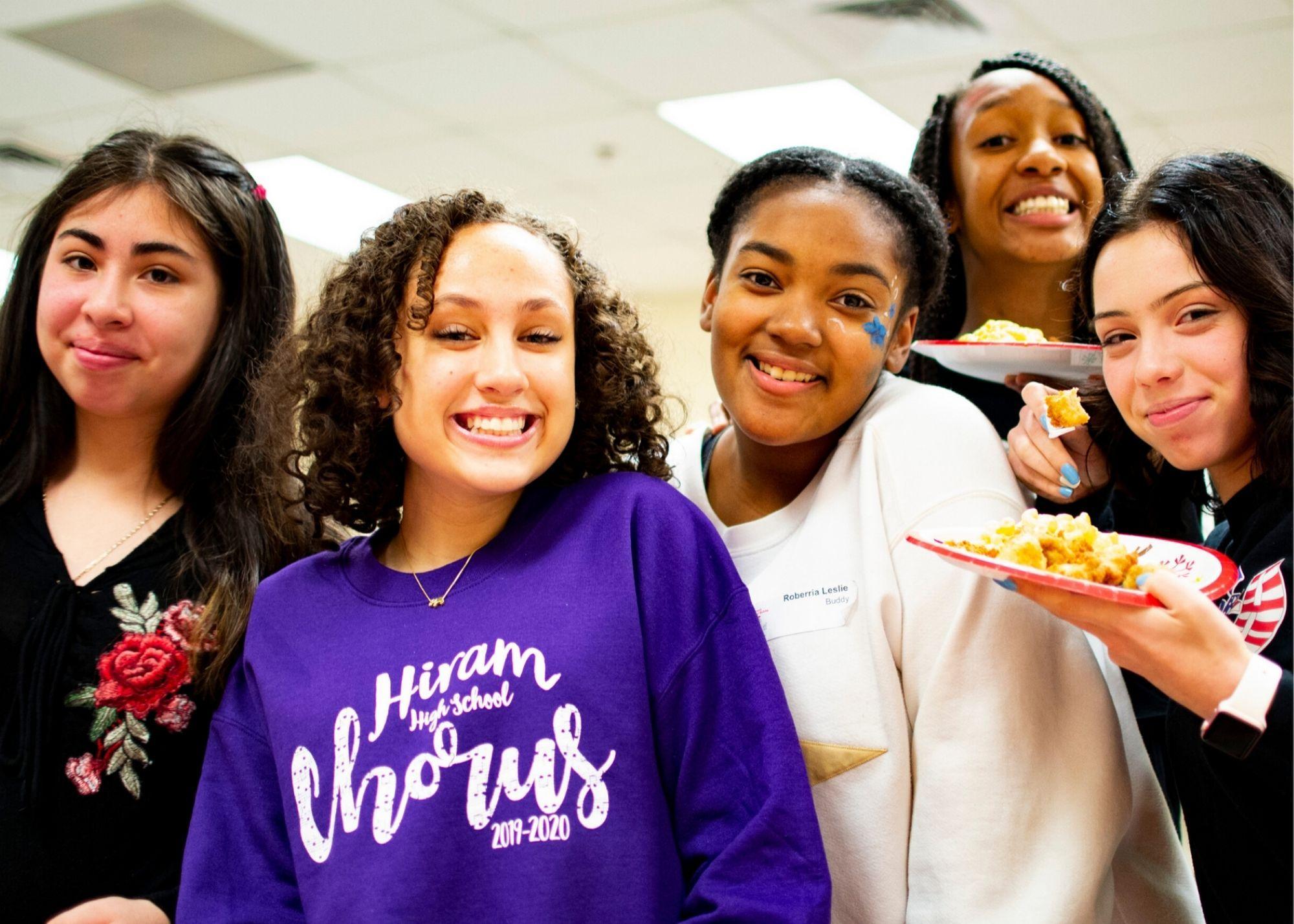 Students smiling and holding plates of food.  / Hiram High School Upward Bound celebrates the holidays and learns about college planning 