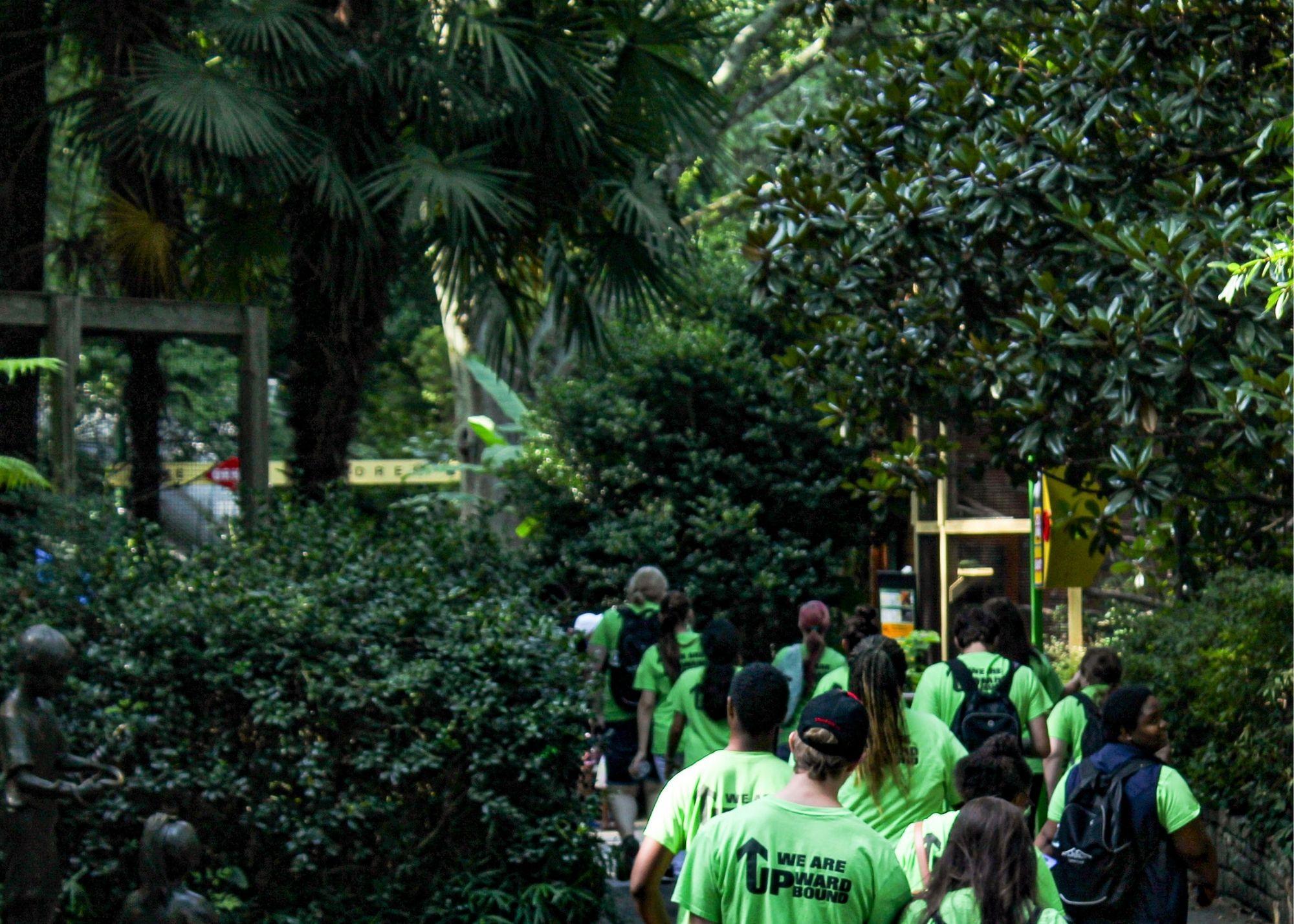 Students wearing green shirts, walking through the Atlanta Zoo. / KSU TRiO Upward Bound at Rockmart and Cedartown High Schools visit the Atlanta Zoo.