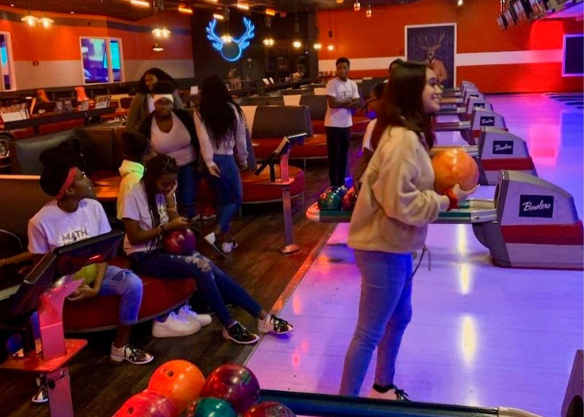 Students at a bowling alley, bowling.  / KSU TRIO students learn the physics behind everyday activities like bowling. 