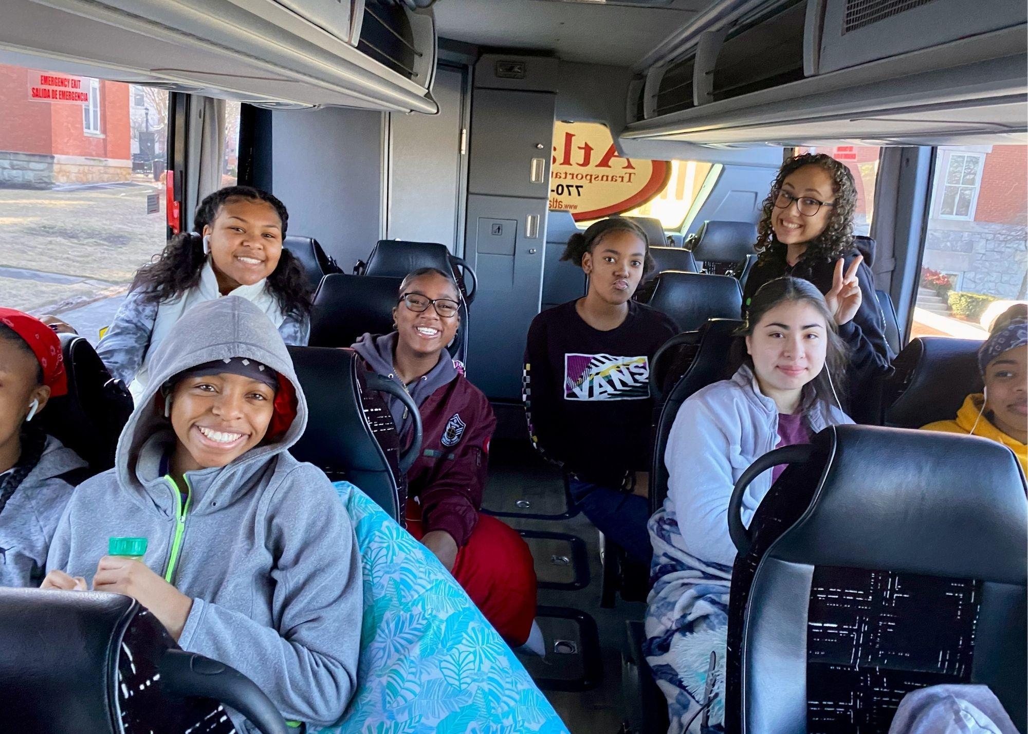 Students smiling while sitting on a bus  / KSU TRIO Students have the opportunity to go on an out of state, educational field trip after full participation in the KSU TRiO Summer Academy. The trip is provided at no cost to students