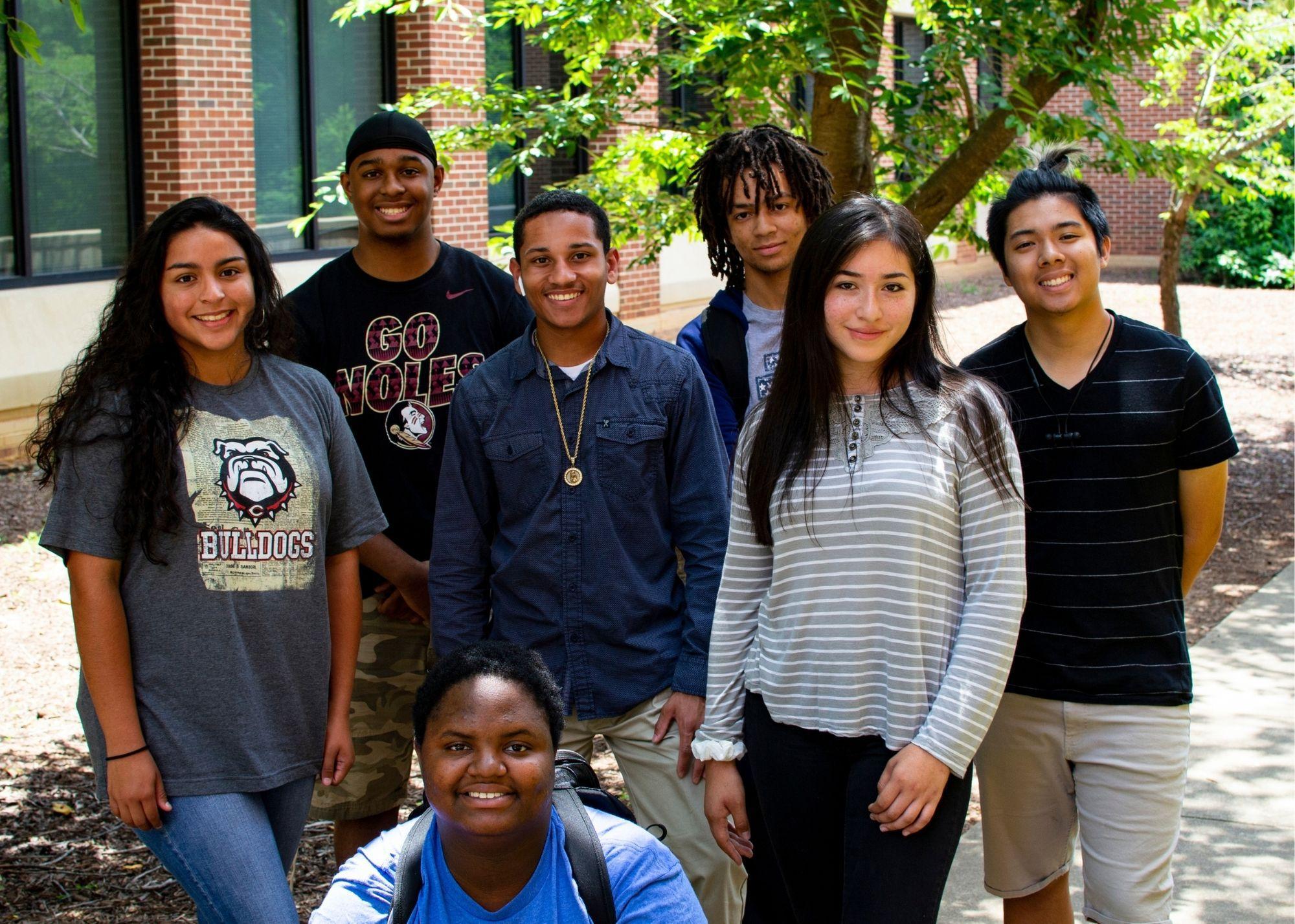 Students smiling and standing outside underneath a tree  / KSU TRiO works with Georgia Highlands College to provide scholarships for KSU TRiO Seniors to receive two free college courses upon graduation 