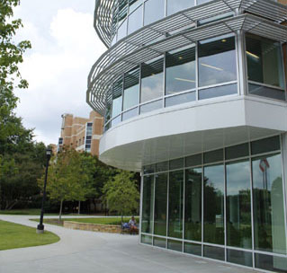 A large building with glass windows, representing the Bagwell College of Education, showcasing modern architectural design.