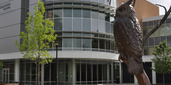 A statue of an owl stands prominently in front of Bagwell College of Education, symbolizing wisdom and learning.