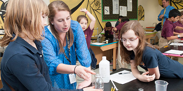 A group of enthusiastic children conducting experiments in a science lab, representing Bagwell College of Education's early childhood educational working environment.