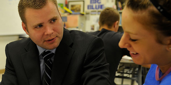 A ksu advisor in formal attire speaks with a woman, possibly about educational advancements and the Doctor of Education program.