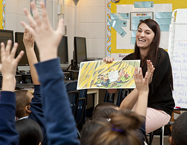 Lady teacher reading to elementary school students