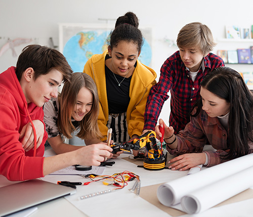 A diverse group of middle school students collaborating on a robotics project, engaging in hands-on STEM learning in a classroom setting.