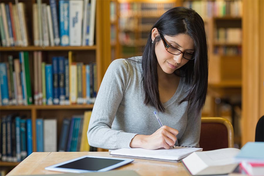 ksu student in the library taking notes.