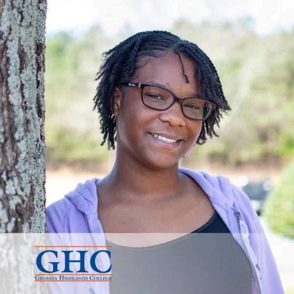 Arielle Johnson, a smiling student standing next to a tree, with the Georgia Highlands College logo in the bottom left corner.