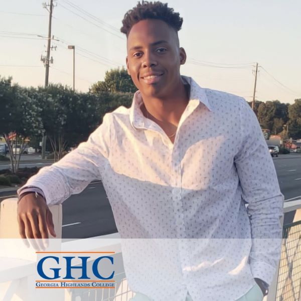 Azer Tidor, a student posing outside near a street, with the Georgia Highlands College logo in the bottom corner.
