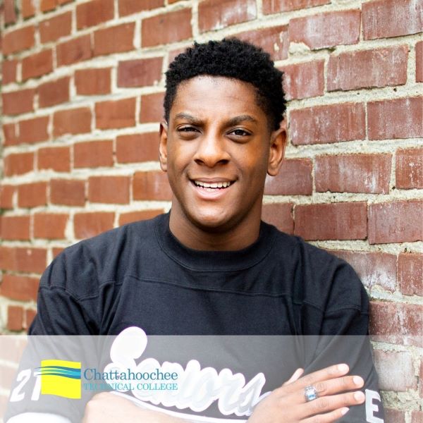 Christopher Hayes, a student leaning against a brick wall, with the Chattahoochee Technical College logo in the bottom left corner.