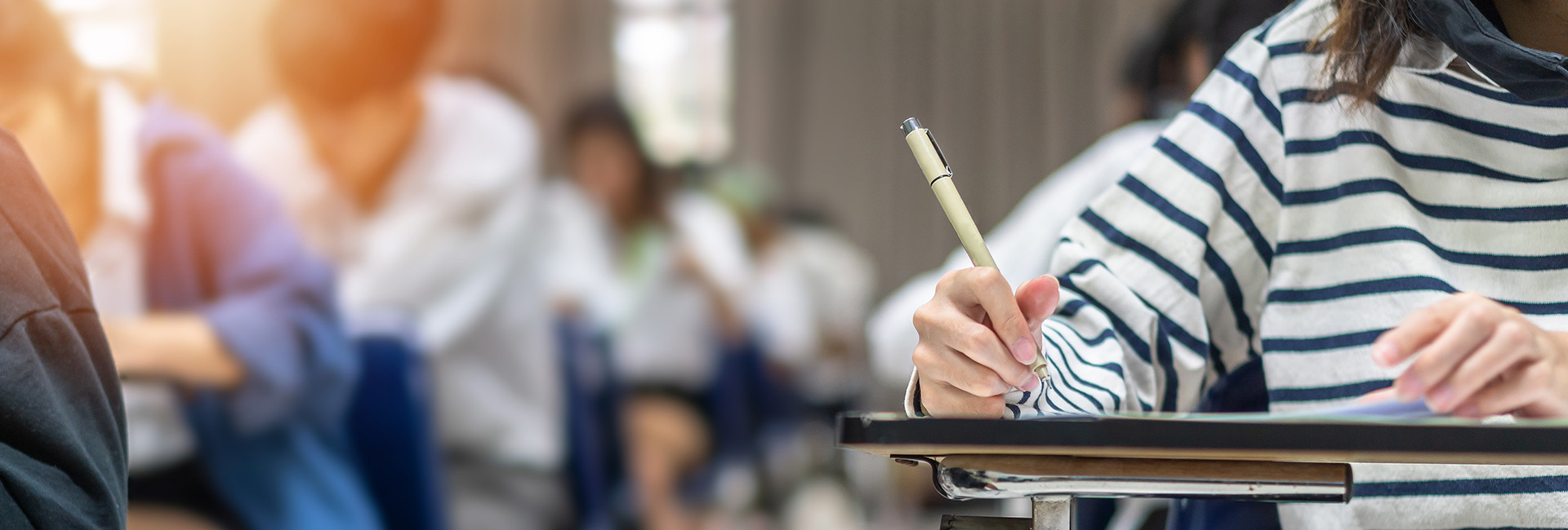faded classroom image student with pen