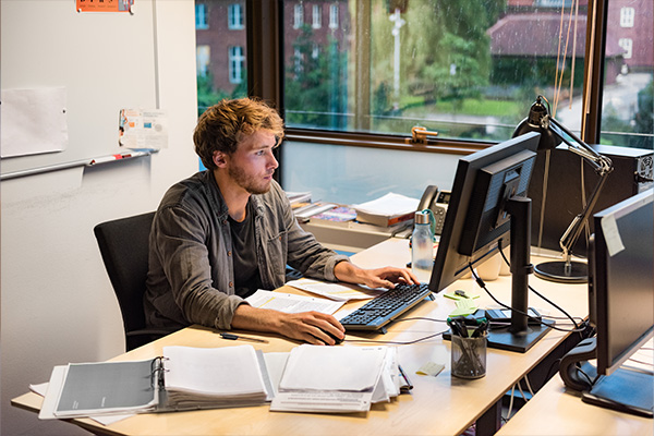 man sitting at desk learning online