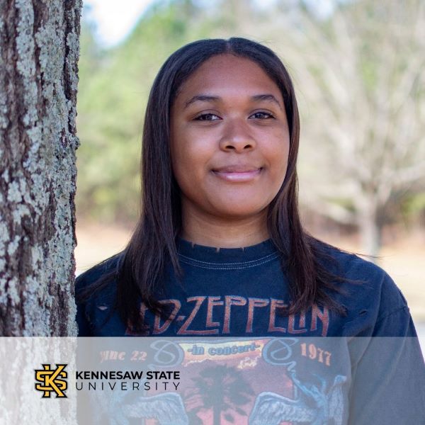Haley Kendrick, a student standing next to a tree, with the Kennesaw State University logo in the bottom left corner.