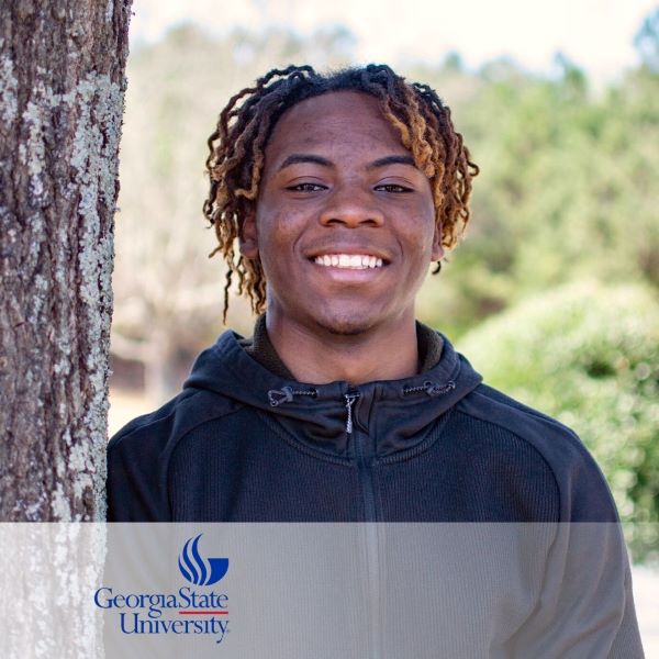 Joshua Heyliger, a smiling student standing next to a tree, with the Georgia State University logo in the bottom left corner.