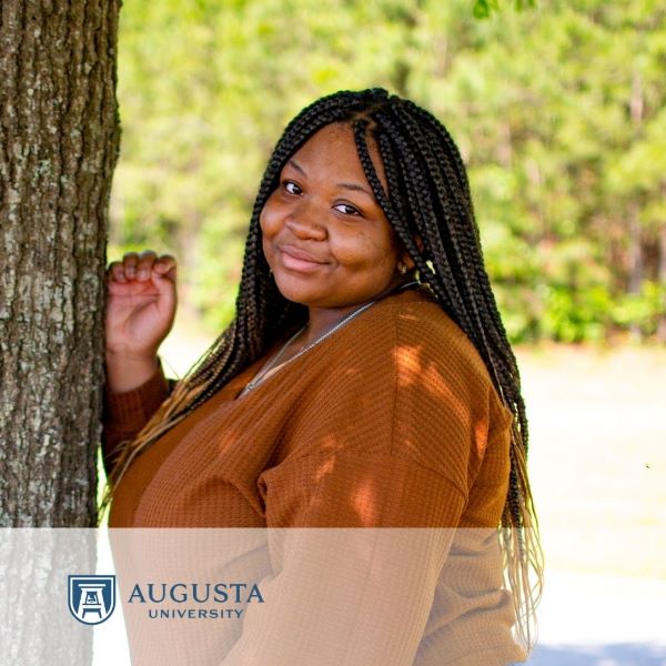 Jayda Lord, in a headshot next to a tree, with the Augusta University logo in the bottom left corner.