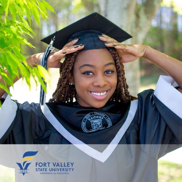 Julie Heyliger, a graduate wearing a cap and gown with the Fort Valley State University logo in the bottom left corner.