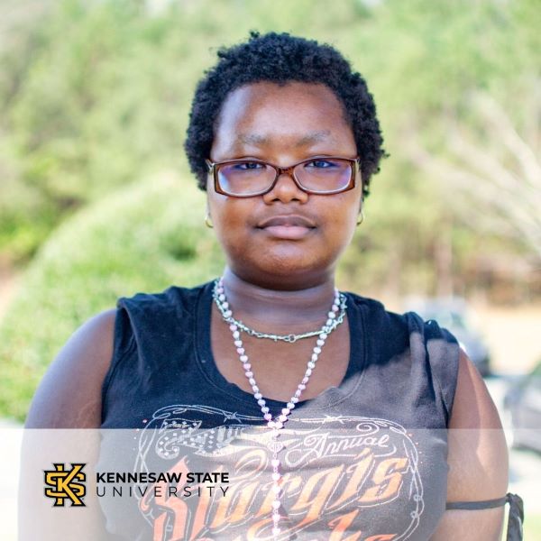 Kayla Wachiuri, in a headshot with the Kennesaw State University logo in the bottom left corner.