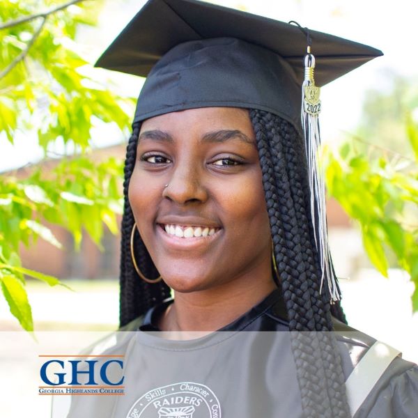 Kalia Warren, a graduate wearing a cap and gown with the Georgia Highlands College logo in the bottom left corner.