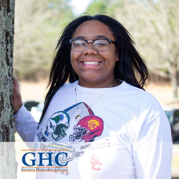 Taneisha Gary, a smiling student standing next to a tree with the Georgia Highlands College logo in the bottom left corner.