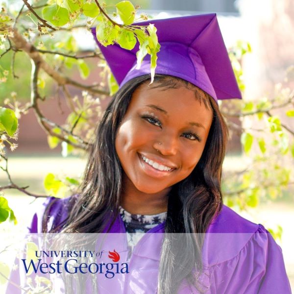 Mya Brewer, a smiling graduate dress in a purple cap and gown with the University of West Georgia logo in the bottom left corner.
