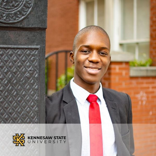 Mauranson Louis, in a headshot with an outdoor setting and the Kennesaw State University logo in the bottom left corner.