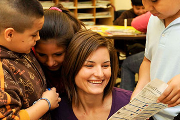 teacher surrounded by elem aged kids