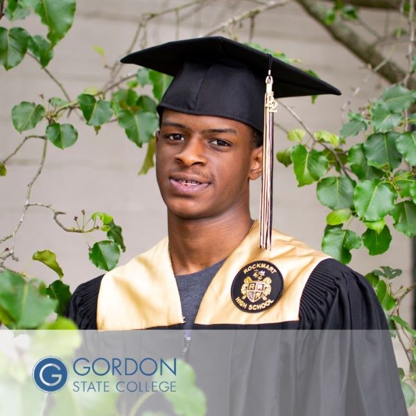 Parnell McKinnon, a graduate dressed in a cap and gown near a tree, with Gordon State College logo in the bottom left corner.
