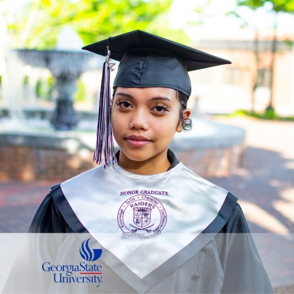 Vannesa Campesino, a graduate wearing a cap and gown, with the Georgia State University logo in the bottom left corner.