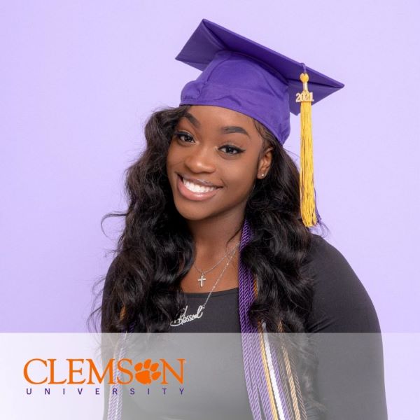 Whitney Delva, a graduate wearing a purple cap, and the Clemson University logo in the bottom left corner.