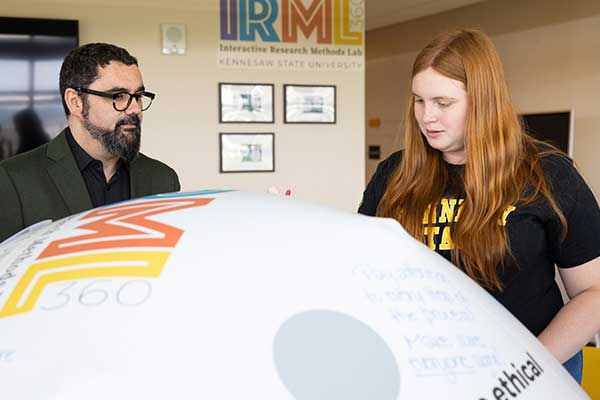 student and professor in interactive research methods lab