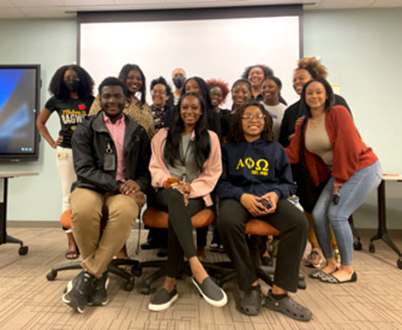 large group of students with their teacher smiling for a picture.
