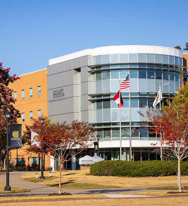 Front view of the Bagwell College of Education at KSU, highlighting a large building with a flag flying