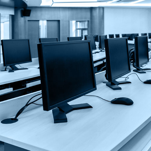 Multiple computer monitors in a row, illustrating a dedicated teacher resource and activity corner for classroom engagement.